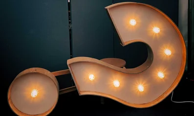 Light bulbs light up a large question mark sign, illustrating the Frequently Asked Questions (FAQ) page.